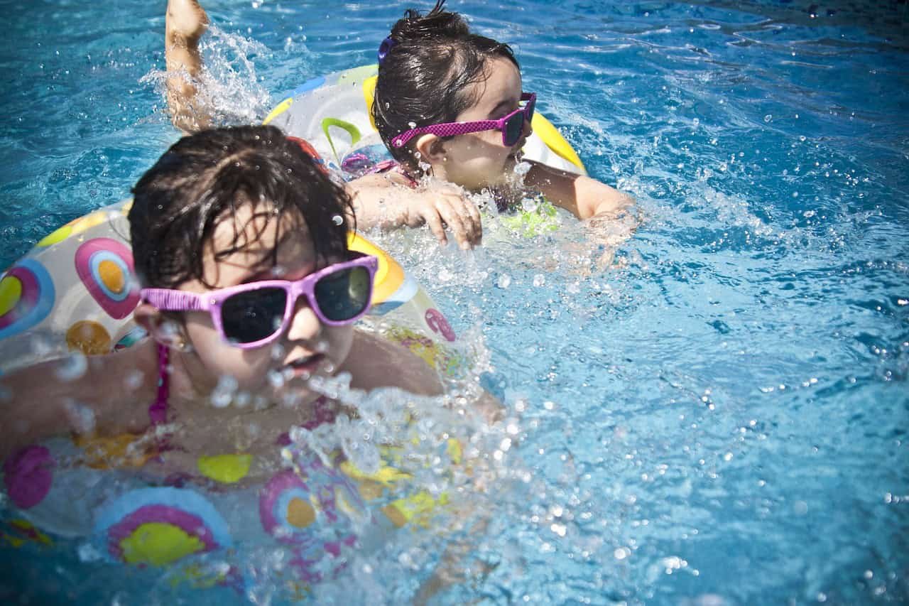 two young girl kids swimming together in the best resort for family in varkala with kids pool